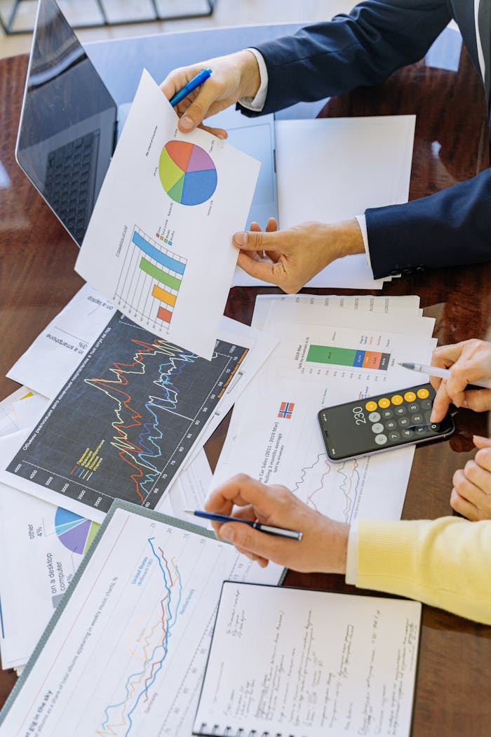 Sobre Nós Business professionals analyzing financial charts and graphs during a meeting.